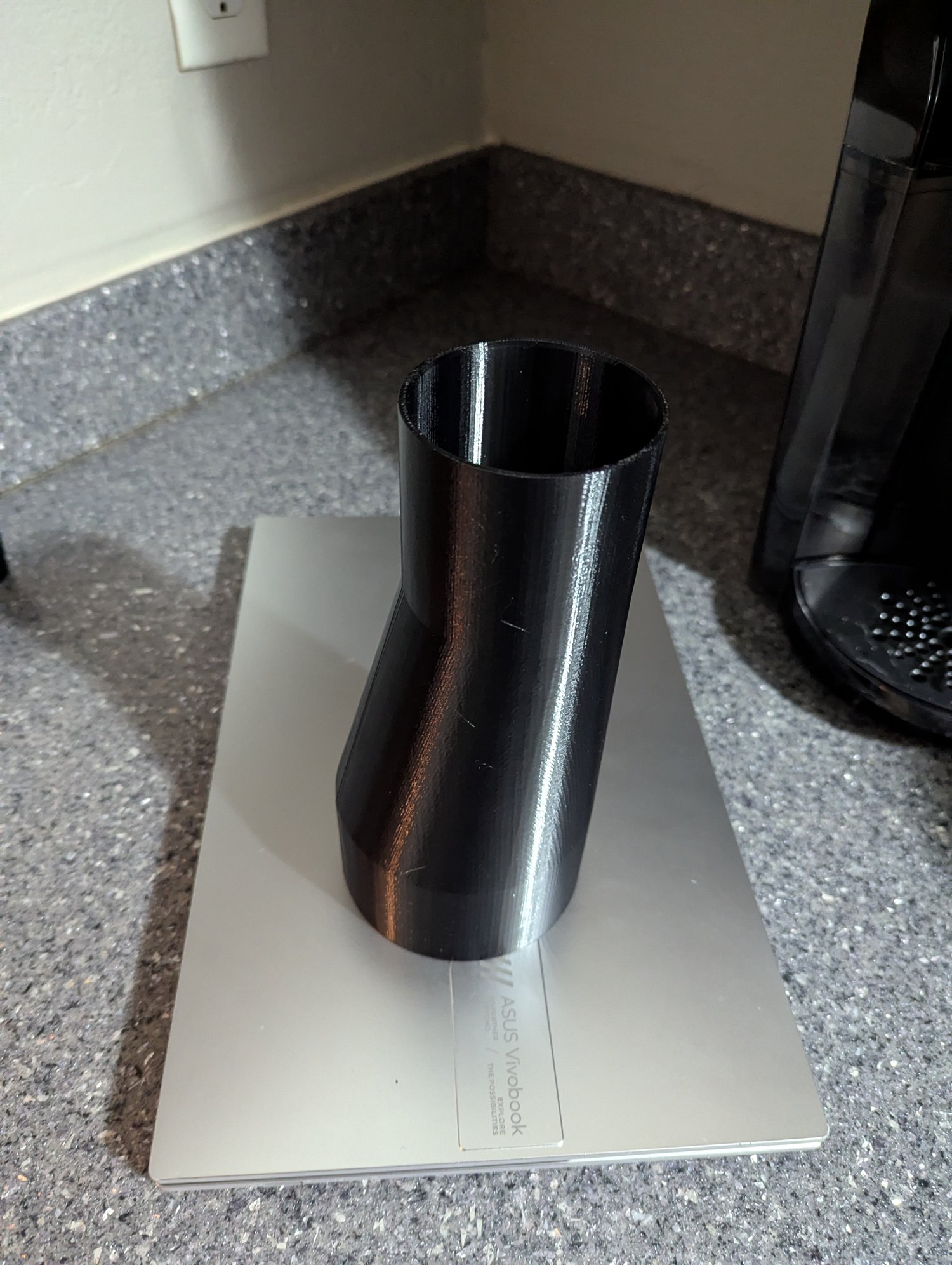 Black 3D-printed boot dust cover standing upright for a CNC machine