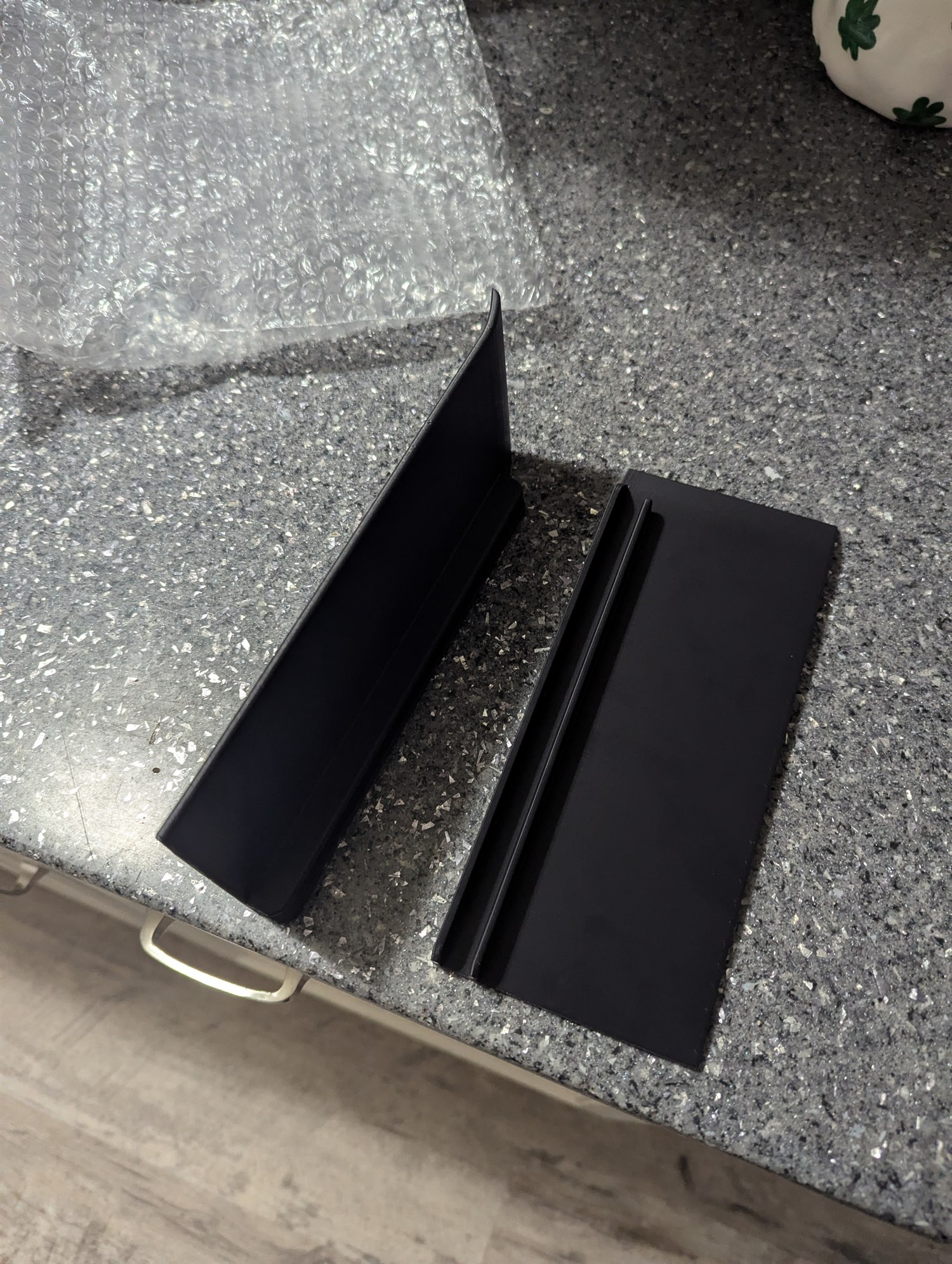 Pair of black 3D-printed generic 5/8-inch vehicle splitter end plates resting on a countertop