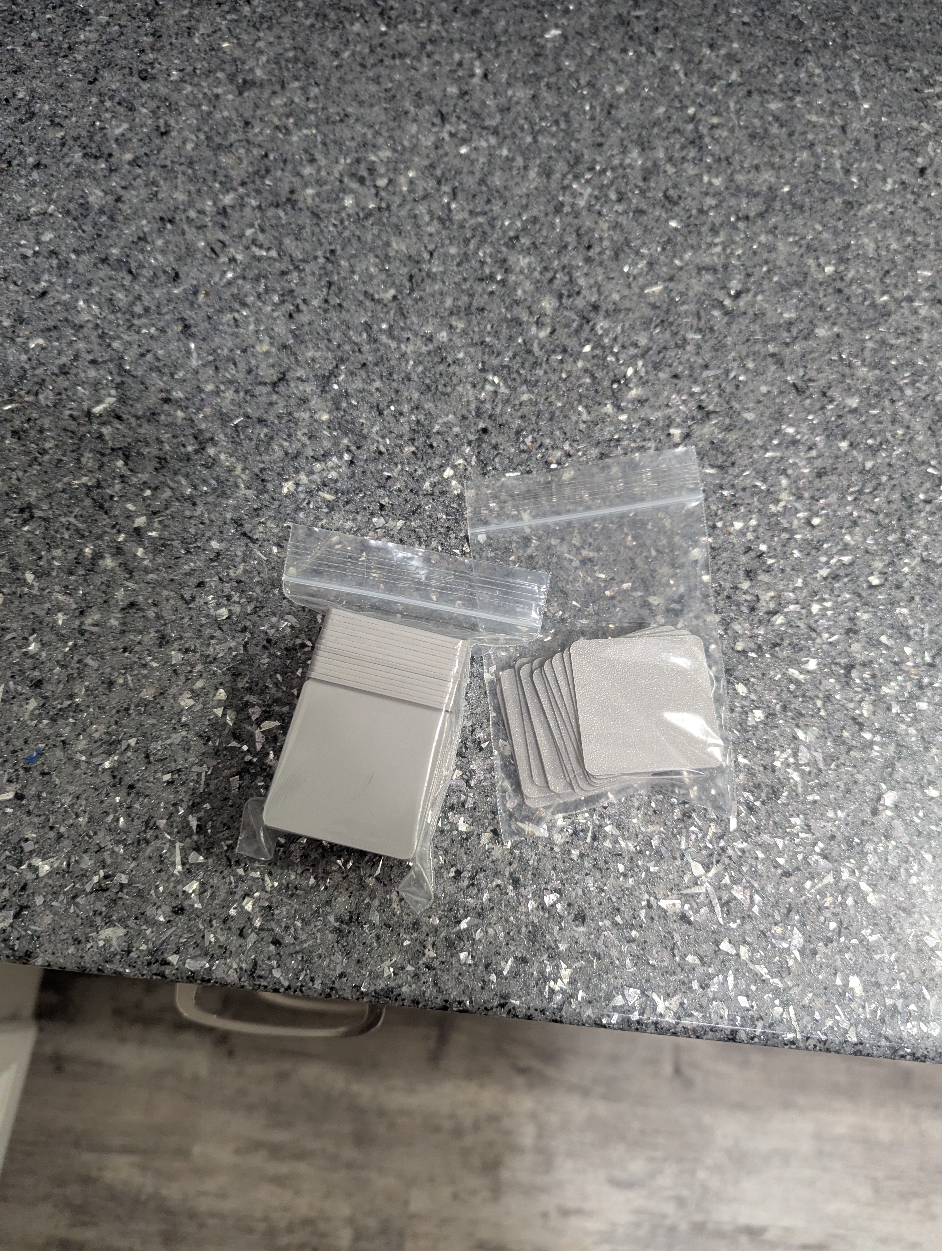 Batch of 50 square gray mini figurine base plates packaged for a customer
